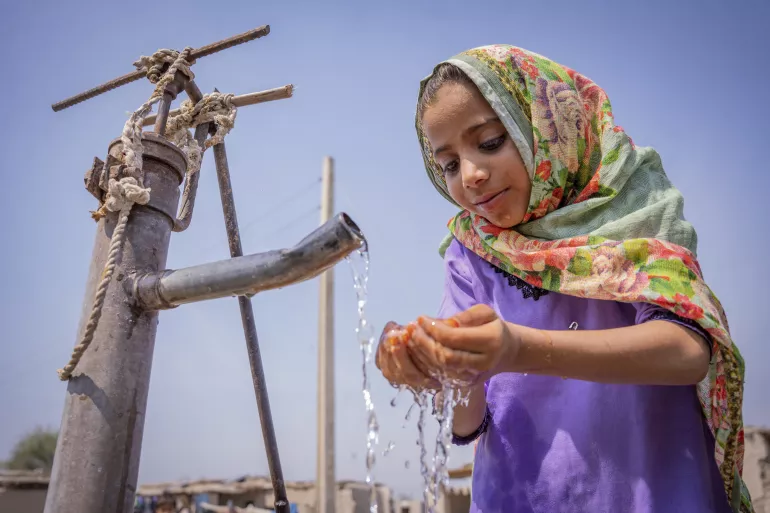 A child drinking clean water from a tap in Pakistan