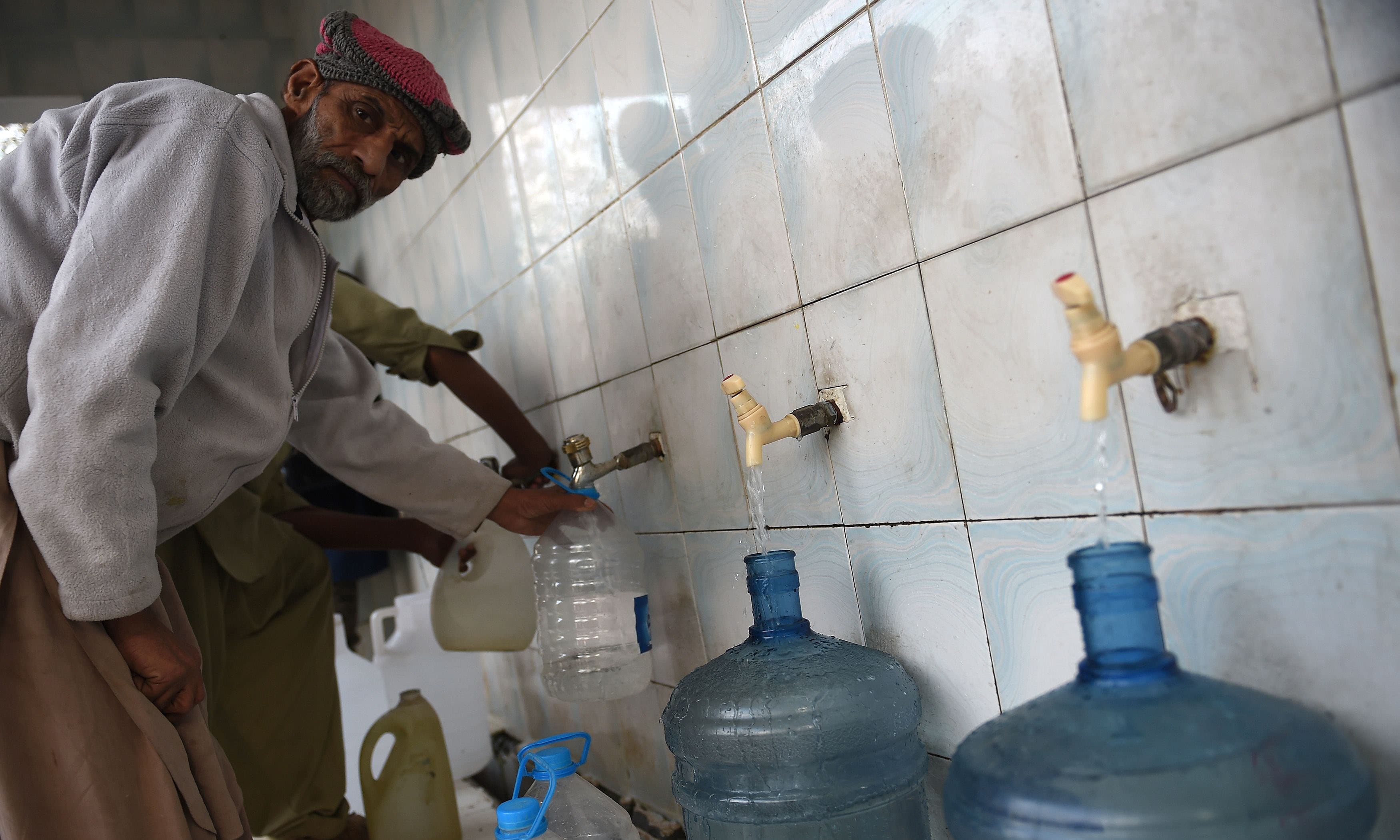Children collecting water at a hand pump in Pakistan