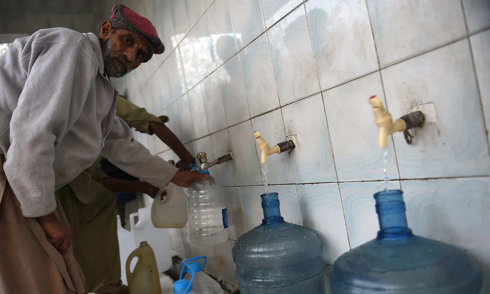 Children collecting water at a hand pump in Pakistan